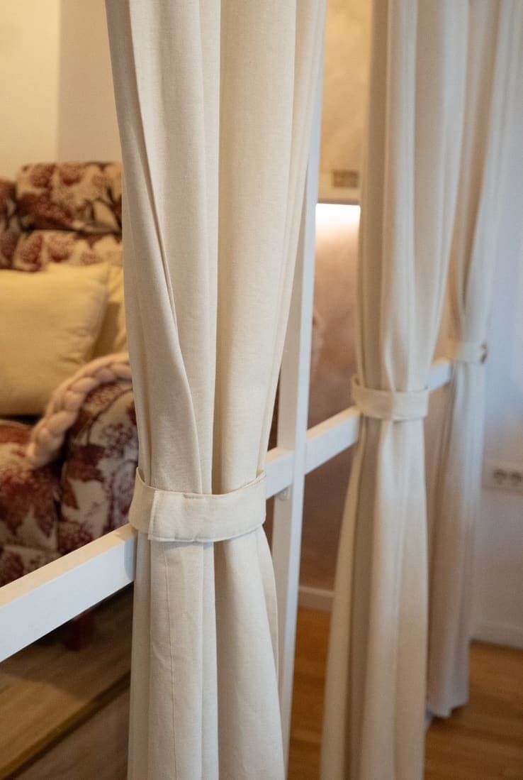 Detalj enterijera Alila Studio Wellbeing — krem zavese i topla svetlost